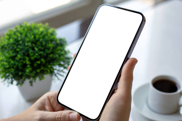 istock female hands holding phone with isolated screen table with coffee 2187084400