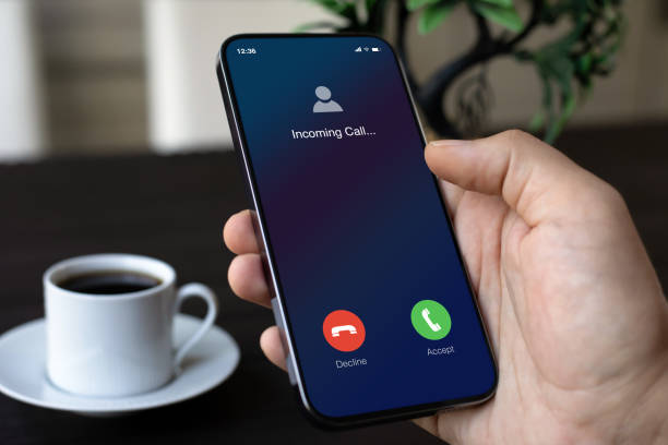 istock male hand holding phone with incoming call screen in office 2187085013
