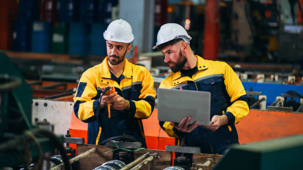 istock Engineers or supervisors inspecting and checking machines in a factory. Workers in the metal sheet industry carrying out their tasks. 2187085663