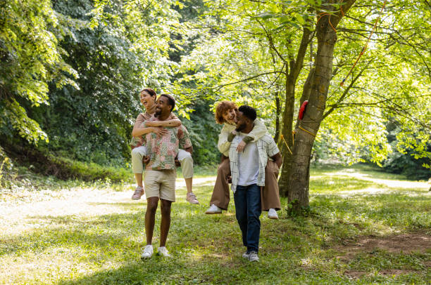 istock Two happy multiracial couples piggybacking in a park 2187086274