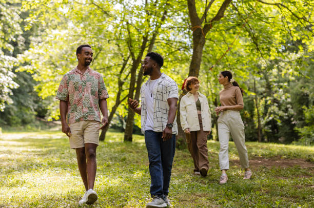 istock Happy multiracial friends walking and talking in summer park 2187086290