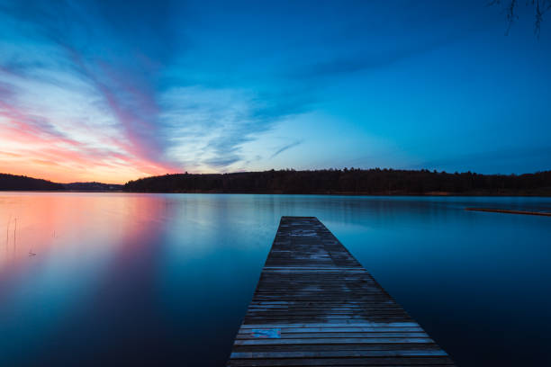 istock Wooden jetty at lake during sunrise 2187086365