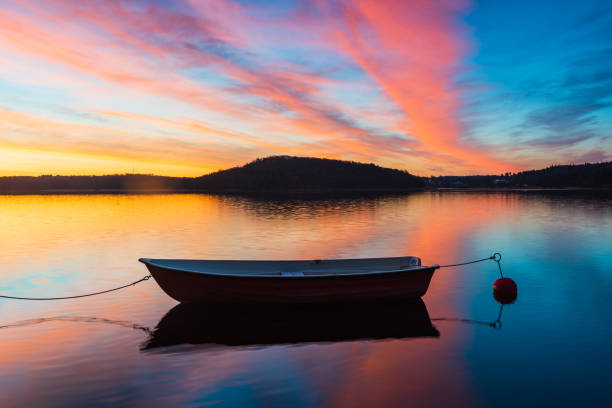 istock Boat lying in still lake at colorful sunrise 2187086370