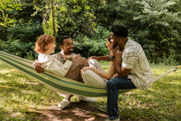 istock Happy multiracial friends relaxing together in hammock 2187087019