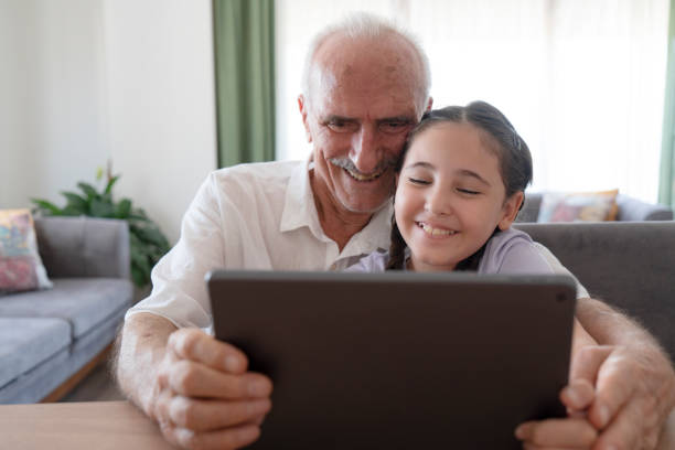 istock Grandfather and granddaughter using tablet 2187087802