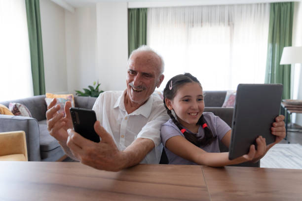 istock Girl and her grandfather using smartphone and digital tablet 2187087969