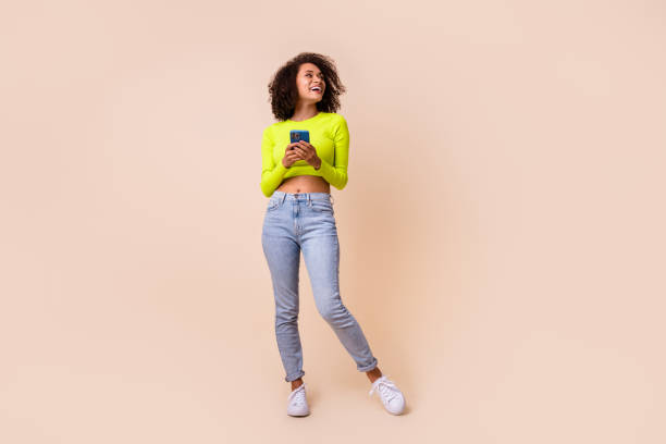 istock Full size photo of young attractive lady hold phone looking empty space smiling bought tariff plan isolated on beige color background 2187088029