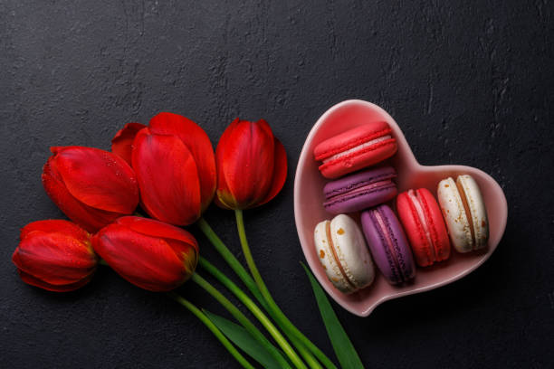 istock Red tulips and vibrant macaroons fill a heart-shaped bowl 2187088680