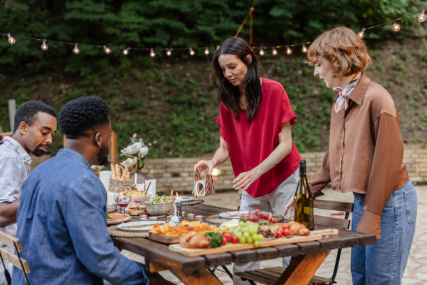 istock Friends preparing table for dinner party in garden 2187088986