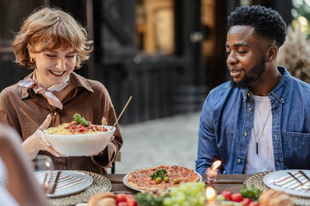 istock Friends enjoying a multiracial party with spaghetti and pizza 2187089030