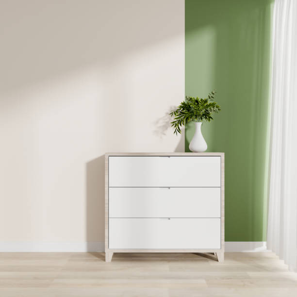 istock A minimalist room features a drawer and sunlight casting soft shadows on the white and green wall. 2187089067
