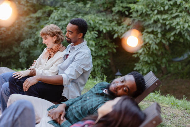 istock Friends enjoying relaxing evening together outdoors at a party 2187089545