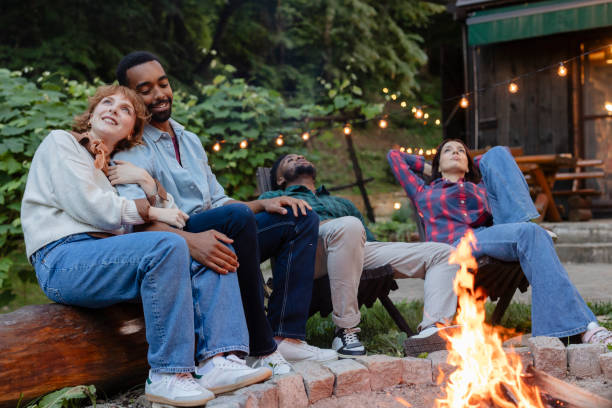istock Friends relaxing around bonfire enjoying summer vacation together 2187089570