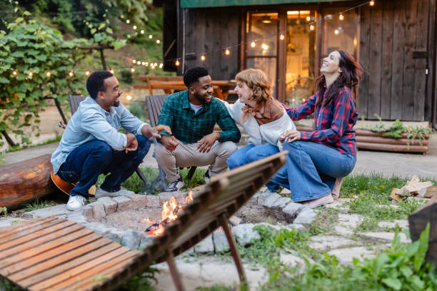 istock Friends gathering around bonfire, enjoying vacation together 2187089758