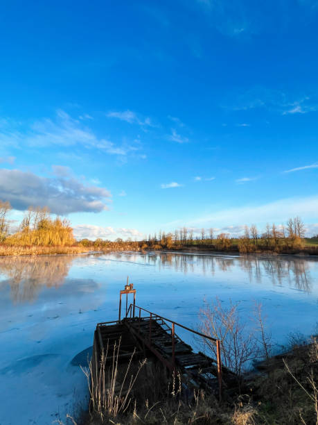 istock Tranquil winter lake with old wooden pier at sunset 2187090408