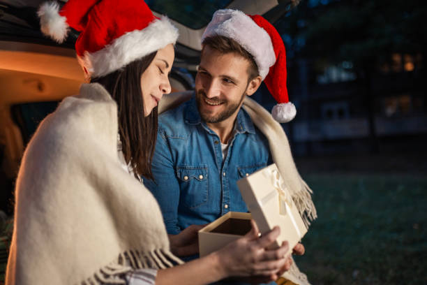 istock Couple Celebrating Christmas Outdoors by Car 2187090464
