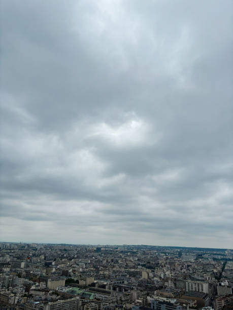 Scenic view of a city sprawling under a thick, overcast sky.Paris, France. The urban landscape stretches into the horizon, depicting a moody and atmospheric ambiance.