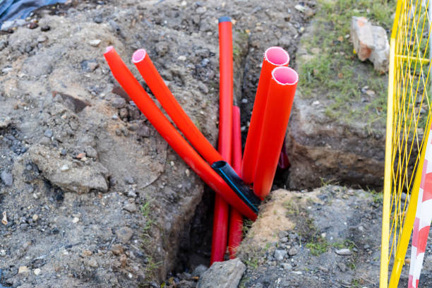 istock several red plastic conduit pipes in ditch 2187091774