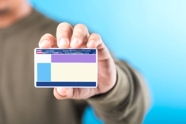 A Thai man holds a blank Smart Card Thailand driver's license, emphasizing the importance of obtaining a license for road safety and responsible driving