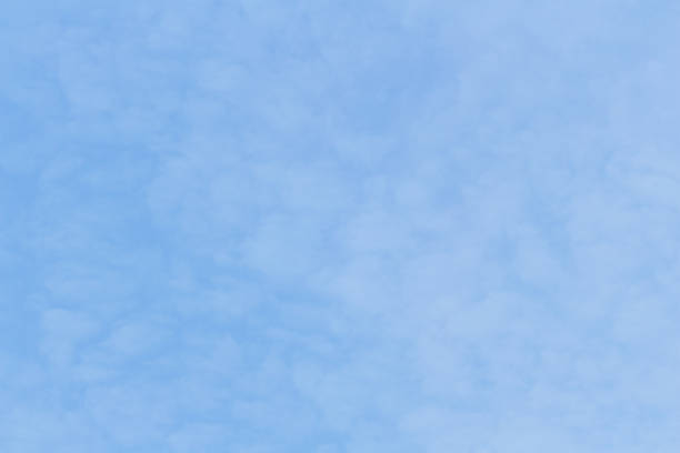 beautiful blue skies with puffy white and colored clouds at sunrise