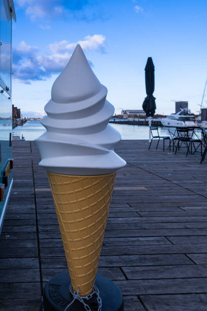 istock Giant plastic ice cream cone stands on a boardwalk by the seaside 2187098951