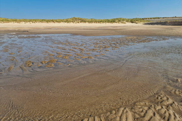 istock Water flowing from sandy beach at low tide 2187100080