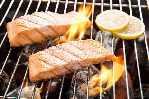 istock Grilled salmon with lemon on the flaming grill. 2187100298