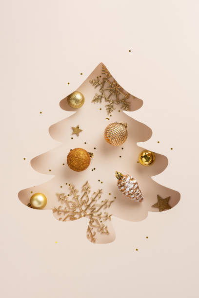 istock A creative vertical Christmas tree cutout adorned with golden baubles and intricate snowflakes, creating a festive holiday ambiance against a neutral background 2187102058