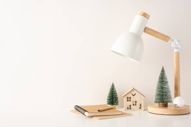 istock A side view minimalist Scandinavian winter workspace featuring a desk lamp, small pine trees, and a wooden house, creating a cozy and peaceful atmosphere 2187102178