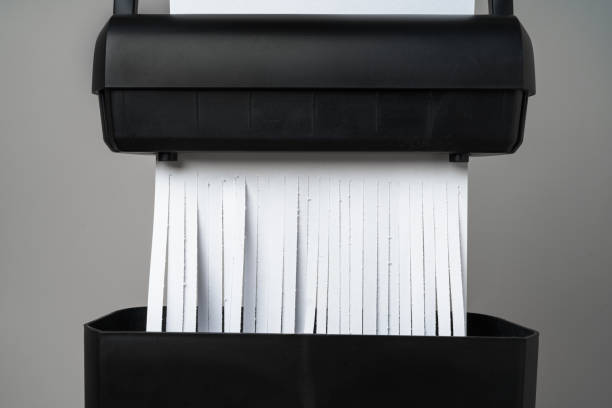 istock Black paper shredder cutting paper on gray background 2187102747