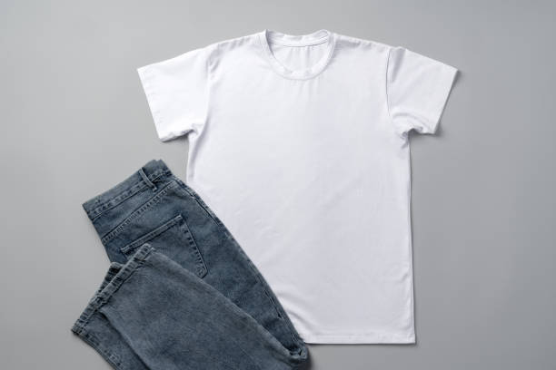 Cotton T-shirt and jeans on gray background top view