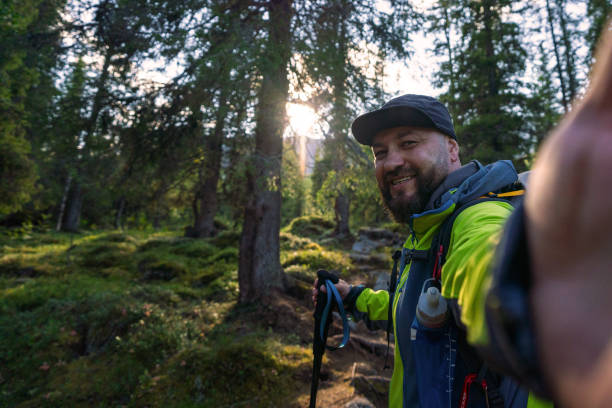 istock Man Hiking in a Forest Taking a Selfie at Sunrise 2187105016