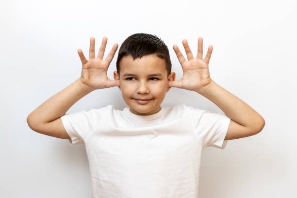 istock The guy grimaces, showing his ears with his palms. Sincere children's emotions. 2187105937