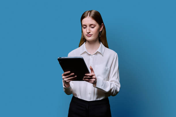 istock Teenager student girl with digital tablet on blue studio background 2187107746