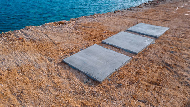 wooden fence made of beams painted brown and screwed into the shape of an x cross at the shore of a pond with a floating plank pier with a rope railing in a city park