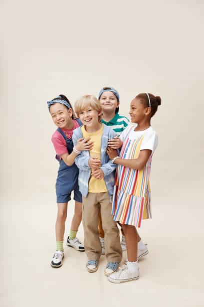 Diverse Group of Friends Hugging Smiling Boy while Having Fun in Studio