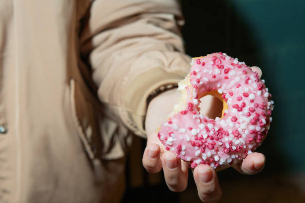 istock Close-up pink frosted donut with sprinkles with bite missing 2187111188