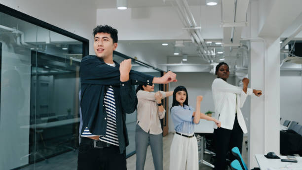 istock A diverse office team participates in group stretching, promoting workplace wellness, flexibility, and a positive team environment. 2187112123