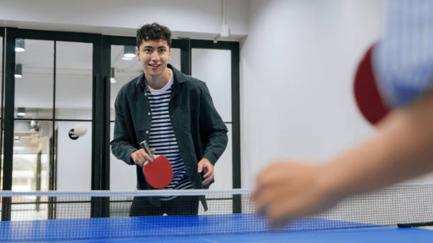 istock Hispanic man Lively Workplace Ping Pong Game Promotes Fun and Team Bonding 2187112153