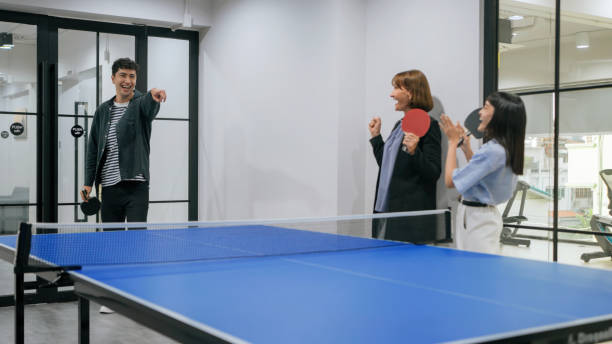 istock A young man holding a paddle during a table tennis match in a modern office space with glass walls. Casual and fun workplace activity. 2187112232