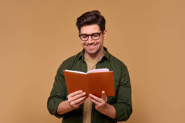 istock A Happy and Smiling Man Enjoys Reading a Book While Surrounded by a Cozy Brown Background 2187112301