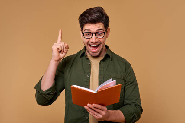 istock An Enthusiastic Young Man with a Book is Celebrating a Great and Exciting Idea Today 2187112309