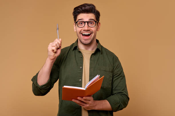 istock An Enthusiastic Young Man with a Book is Celebrating a Great and Exciting Idea Today 2187112341