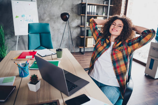 istock Young professional woman relaxing in casual style at modern office setting with checkered shirt 2187117524