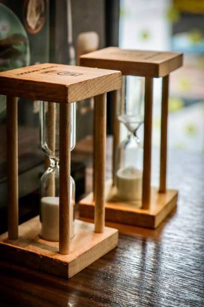 istock Wooden hourglasses with flowing sand on display 2187118979