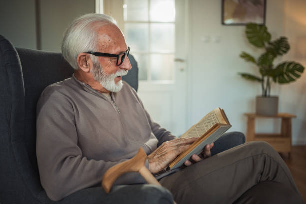 istock An elderly man reads a book at home while relaxing in his comfortable armchair 2187119178