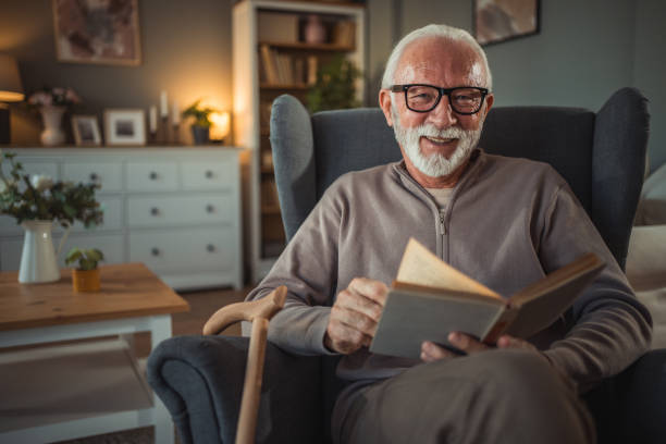 istock An elderly man reads a book at home while relaxing in his comfortable armchair 2187119181