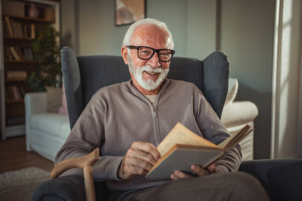 istock An elderly man reads a book at home while relaxing in his comfortable armchair 2187119183