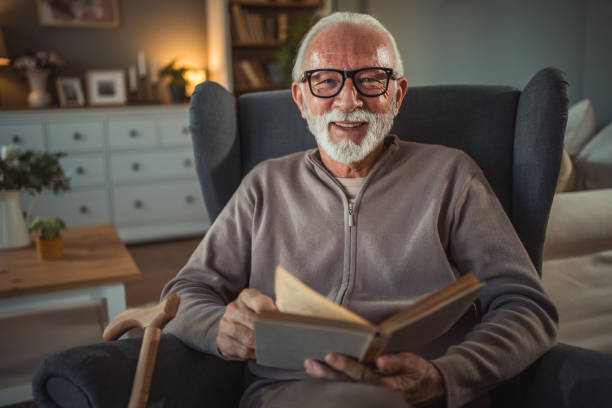 istock An elderly man reads a book at home while relaxing in his comfortable armchair 2187119190