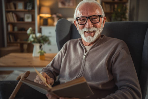istock An elderly man reads a book at home while relaxing in his comfortable armchair 2187119199